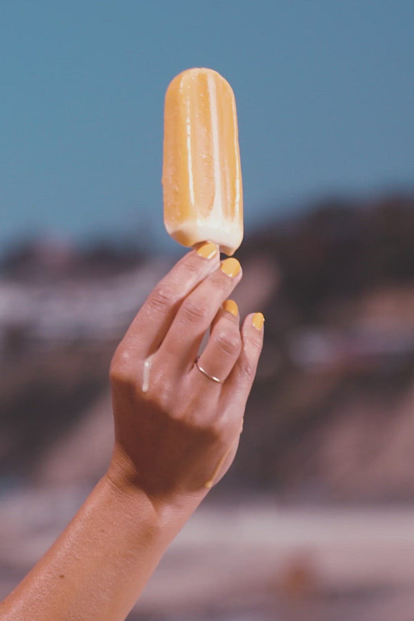 Video of a hand holding a melting popsicle, someone wearing blue and yellow polkadot shorts, and a close up of a woman with her hands on her face.